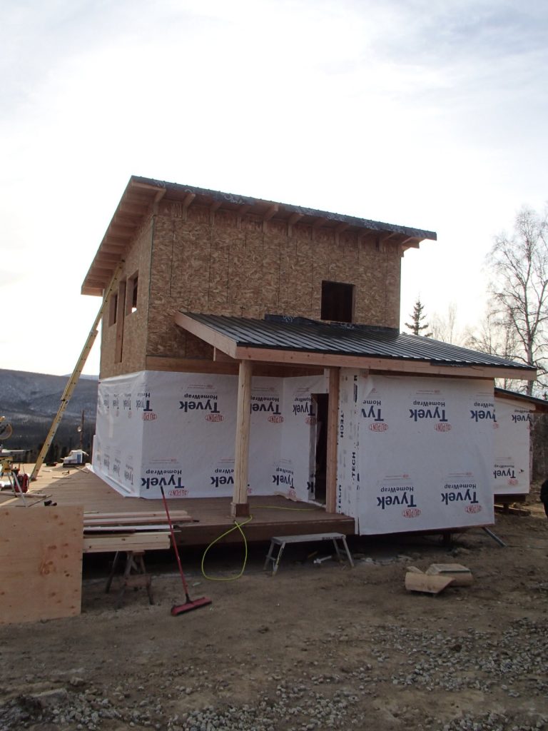 Wrapping the house to seal it, you can see the new front porch and covered entry.